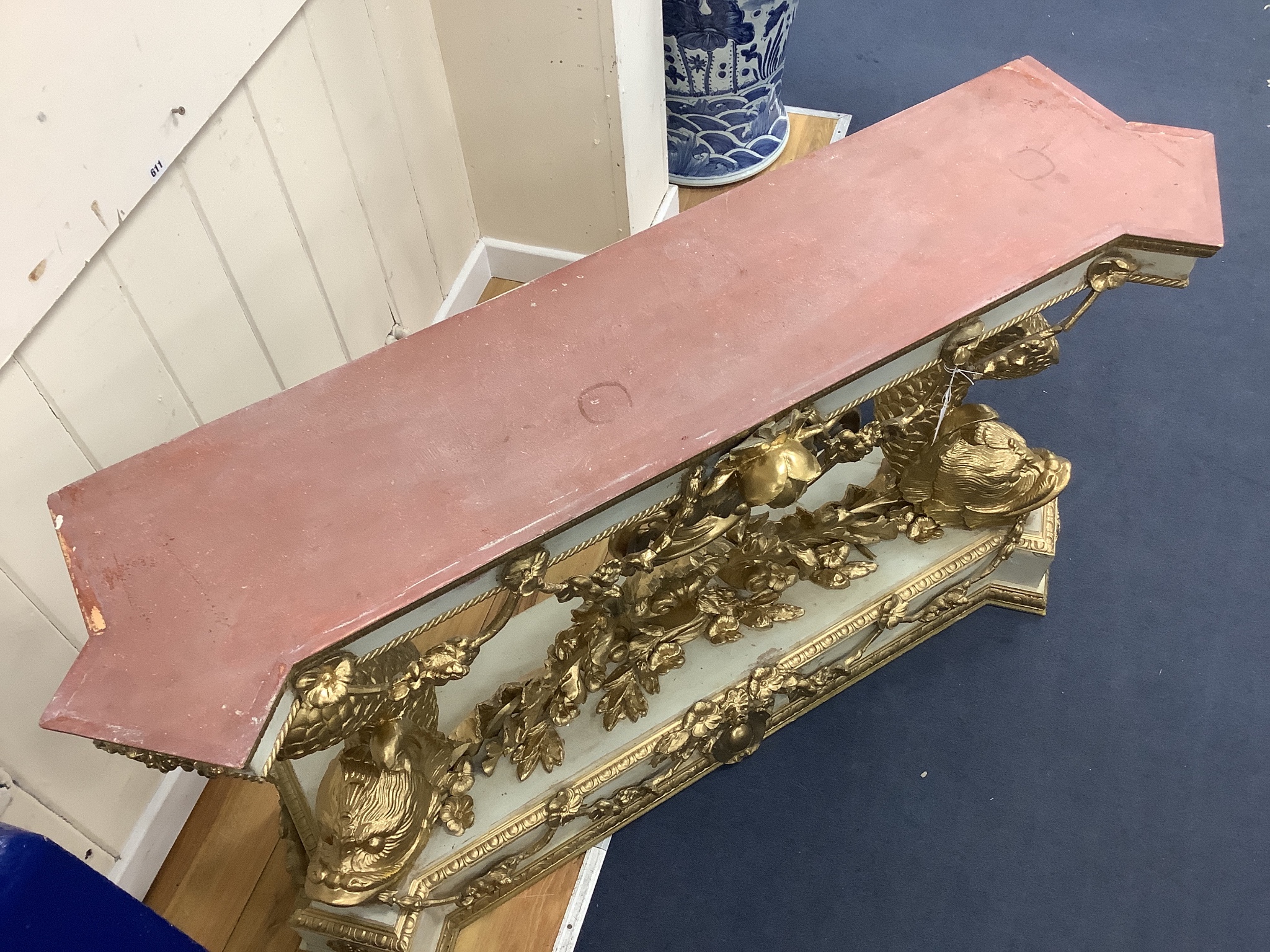 A Louis XVI style painted composition and giltwood console table on dolphin supports, width 146cm, depth 43cm, height 85cm